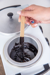 Preparation of wax for shugaring. Close-up wax for depilation is heated and melted in a round...