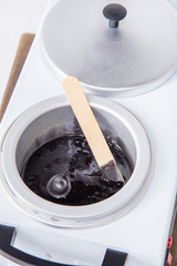 Preparation of wax for shugaring. Close-up wax for depilation is heated and melted in a round container