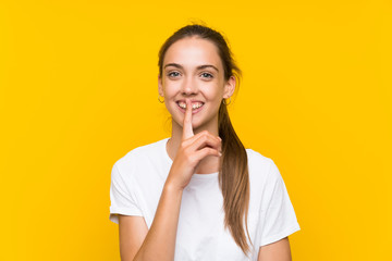 Young woman over isolated yellow background doing silence gesture