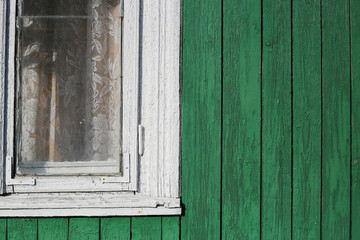 Obraz na płótnie Canvas Part of white window and green wooden wall. Part of typical house in Lithuania, Trakai