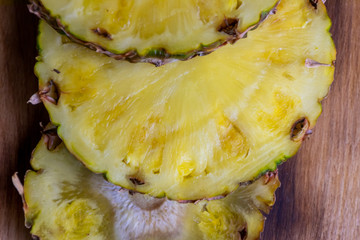 Ripe pineapple and pineapple slices on a wooden background tropical fruits