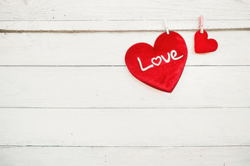 Love hearts hanging on rope on a white wooden background
