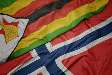 waving colorful flag of norway and national flag of zimbabwe.