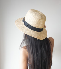 Back view of long straight black hair girl with hat.