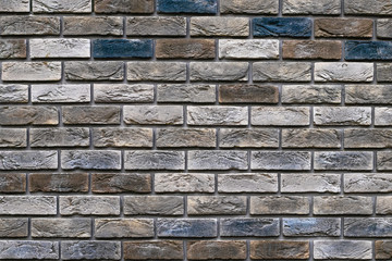 Vintage multi-colored bricks background, grunge texture. Old weathered brick wall. Decorative tile surface. Rough brickwork.