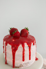 Small fresh strawberry cake with strawberry glaze, three tier cake, white background, copy space
