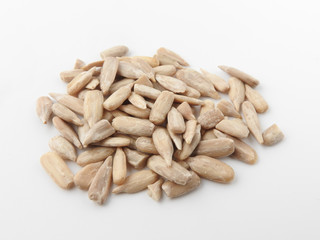 Top view of a pile of natural shelled organic sunflower seeds isolated on white background. It often eaten as a snack.  The seeds contain vitamin E. Food and snack concept. With copy space.