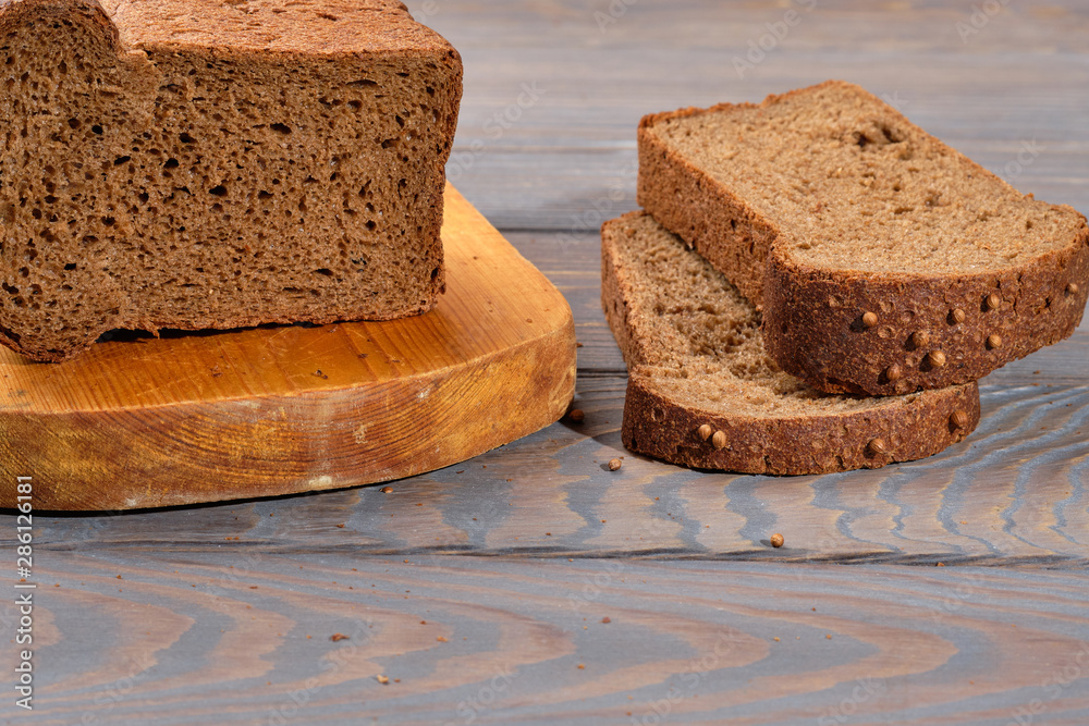 Wall mural loaf of dark bread partly cut in slices