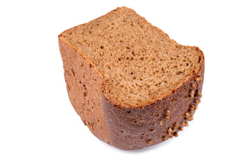 loaf of dark bread partly cut in slices, isolated on white