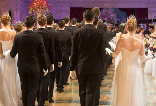 women in dresses and men in suits at the ball