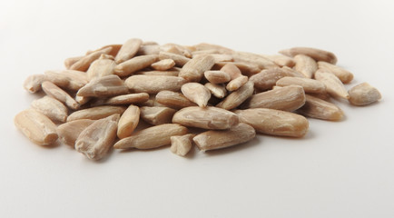 Front view of a pile of natural shelled organic sunflower seeds isolated on white background. It often eaten as a snack.  The seeds contain vitamin E. Food and snack concept. With copy space.