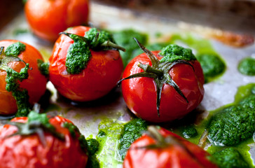 Close up of roasted cherry tomatoes with basil oil