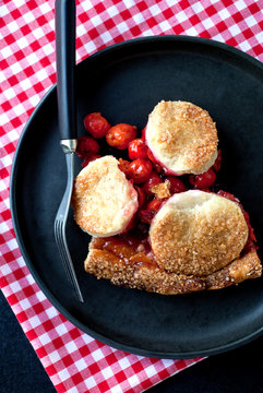 Overhead view of baked sour cherry pie served on plate