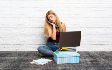 Teenager girl sitting on the floor with her laptop with toothache