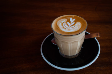 Close up hot Latte with Latte art place on wood table.