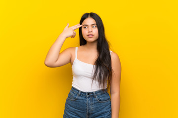 Young teenager Asian girl over isolated yellow background with problems making suicide gesture