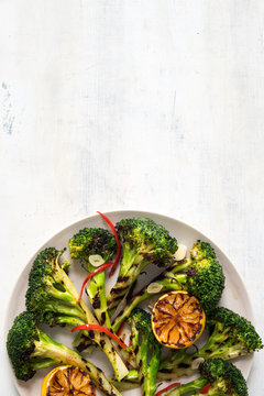 Overhead view of grilled broccoli and lemon served on plate