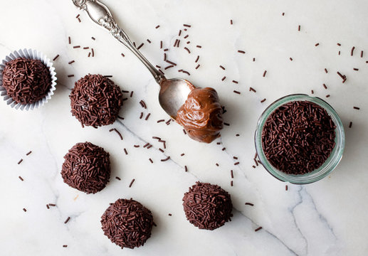 Overhead view of salted licorice brigadeiros on marble