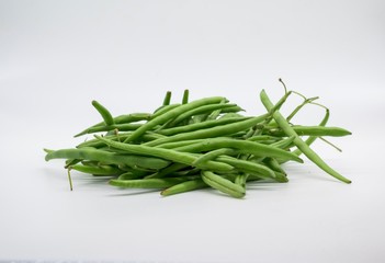 A handful of green beans fresh from the market in front of white background