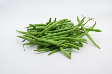 A handful of green beans fresh from the market in front of white background
