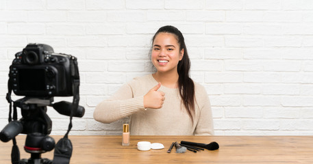 Young blogger Asian girl recording a video tutorial giving a thumbs up gesture