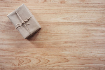 Brown gift box on wooden table background with copy space