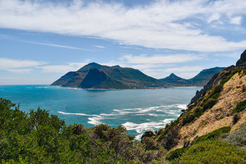 Hout Bay and suurounding mountains against sea and sky on summer day