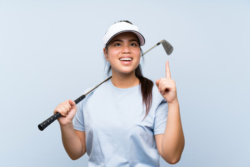 Young golfer Asian girl over isolated blue background intending to realizes the solution while lifting a finger up