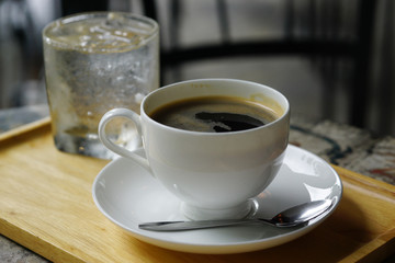 Close Up cup of coffee in a wooden tray on iron table
