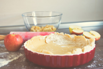 Traditional homemade apple pie and ingredients on wooden background for autumn holiday