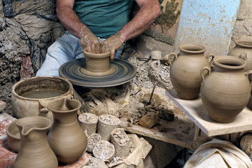Potter using wheel and displayed pots at Damalas, Naxos, GreekIslands