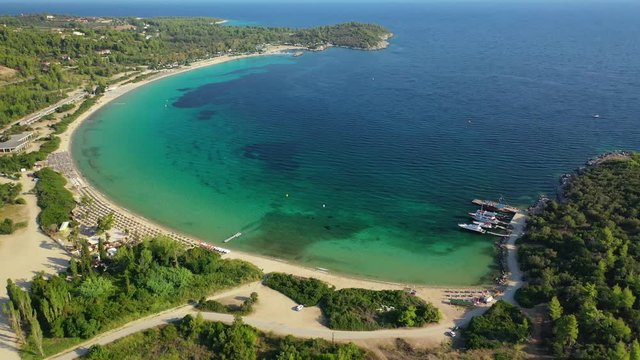 Aerial drone view video of iconic sandy bay and turquoise beach of Paliouri in Kassandra Peninsula, Halkidiki, North Greece