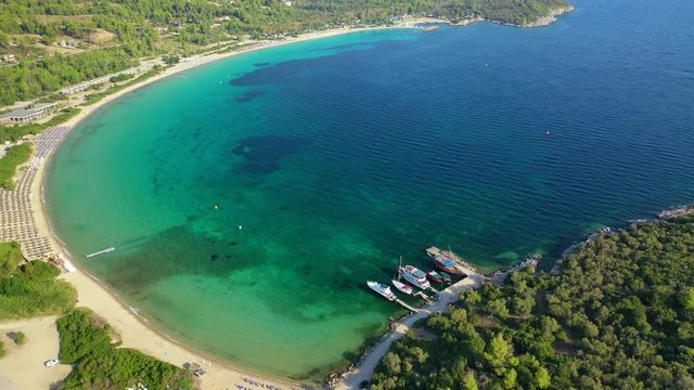Aerial drone view video of iconic sandy bay and turquoise beach of Paliouri in Kassandra Peninsula, Halkidiki, North Greece