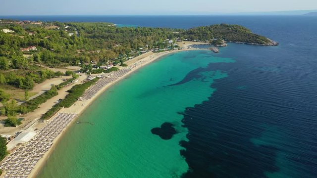 Aerial drone view video of iconic sandy bay and turquoise beach of Paliouri in Kassandra Peninsula, Halkidiki, North Greece