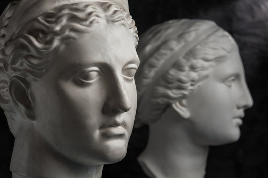 Gypsum copy of ancient statue Venus and Diana head on dark textured background. Plaster sculpture face.