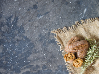 rye bread and oats on a burlap napkin on concrete gray background