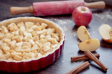 Traditional homemade apple pie and ingredients on wooden background for autumn holiday
