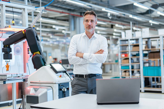 Portrait of a confident businessman in a modern factory hall