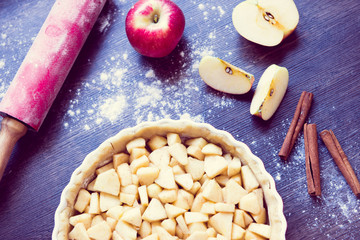 Traditional homemade apple pie and ingredients on wooden background for autumn holiday