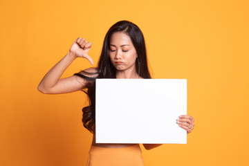 Fototapeta premium Young Asian woman show thumbs down with white blank sign.