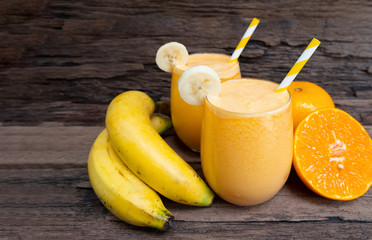 Banana mix orange smoothies yellow colorful fruit juice milkshake blend beverage healthy high protein the taste yummy In glass,drink to lose weight drink episode on wooden background.
