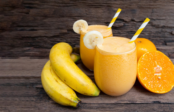 Banana mix orange smoothies yellow colorful fruit juice milkshake blend beverage healthy high protein the taste yummy In glass,drink to lose weight drink episode on wooden background.