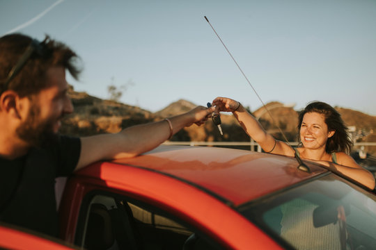 Couple exchanging car keys on a road trip