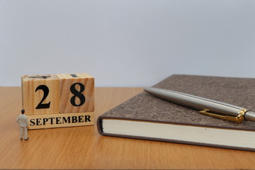 September  28, a calendar photo from the wood The table top consists of a book and pen that is ready to use. White background