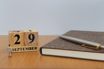 September  29, a calendar photo from the wood The table top consists of a book and pen that is ready to use. White background