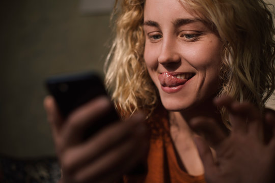 Portrait of blond young woman using cell phone for video chat