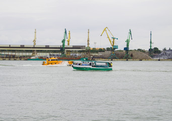Fototapeta premium Boat trip around the bay, equator of the seaport, orange and green boats