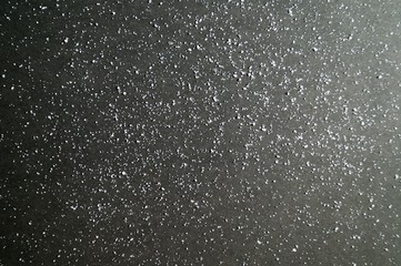 background of Rough Uneven Crystals of shallow salt on a dark gray and black table. Abstract Grunge. Background for advertising salt. Salted food. concept excessive salt intake. selective focus.
