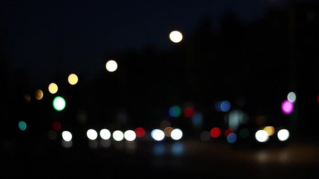 Lights of the night city background. Defocus headlights of moving cars urban traffic. Abstract bright blured colored bokeh.