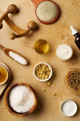 Spa beauty skincare flatlay on travertine background. Body brush, serum and ingredients for scrubs. View from above, copy space